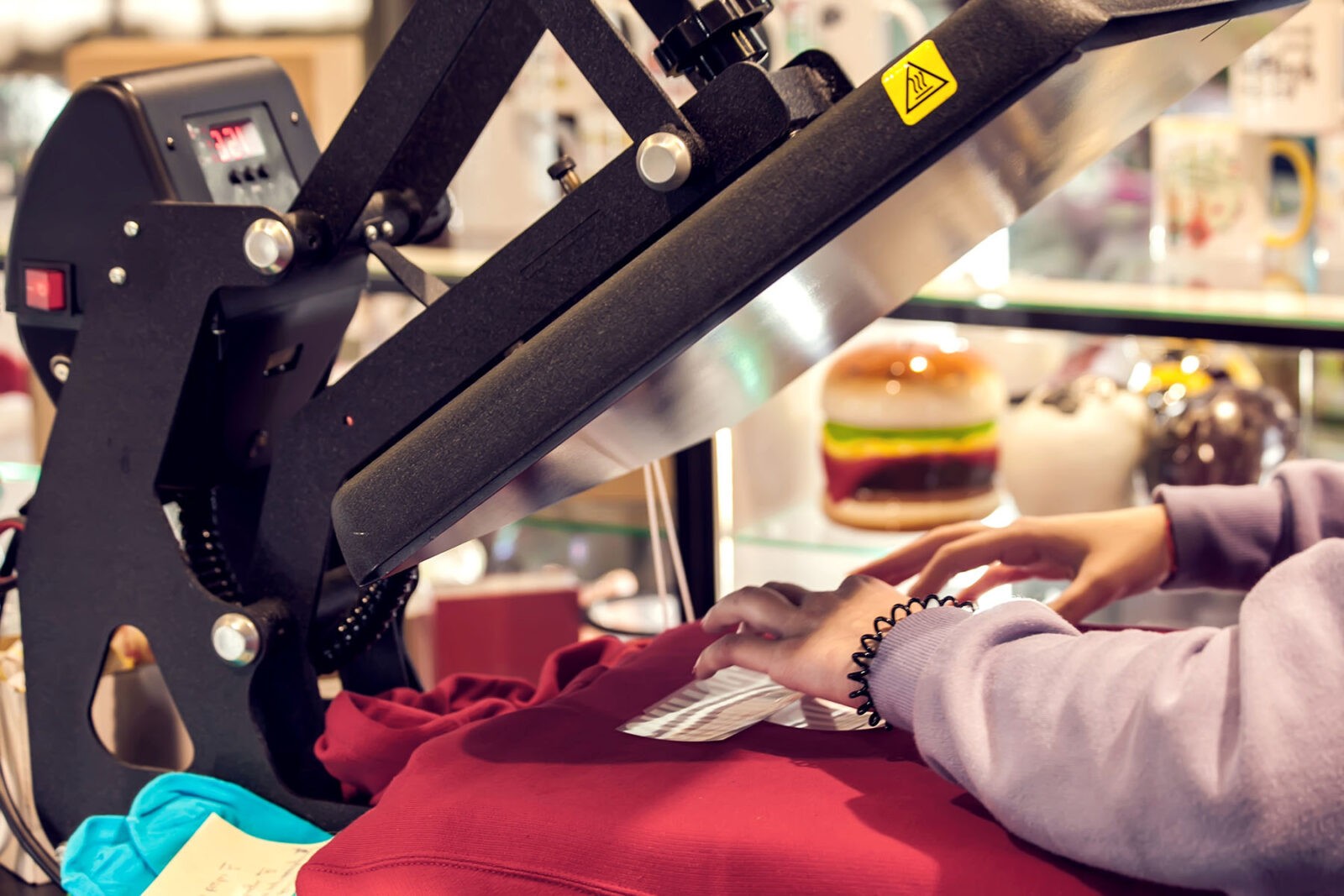 Man preparing t-shirt for a print in a workshop.